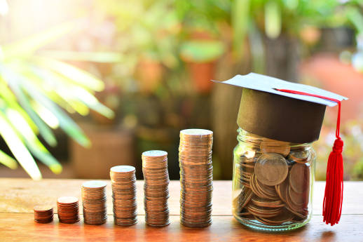 tuition money on table with a graduation cap