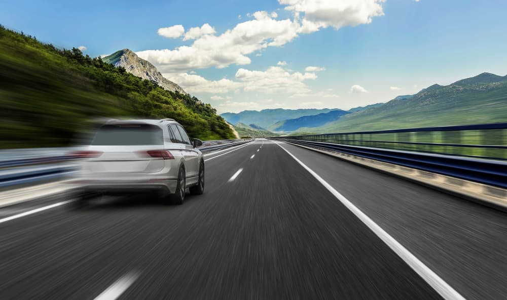 white car rushing along high-speed highway