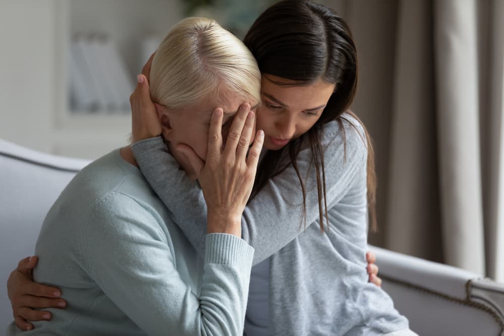 Empathic young lady embracing soothing crying