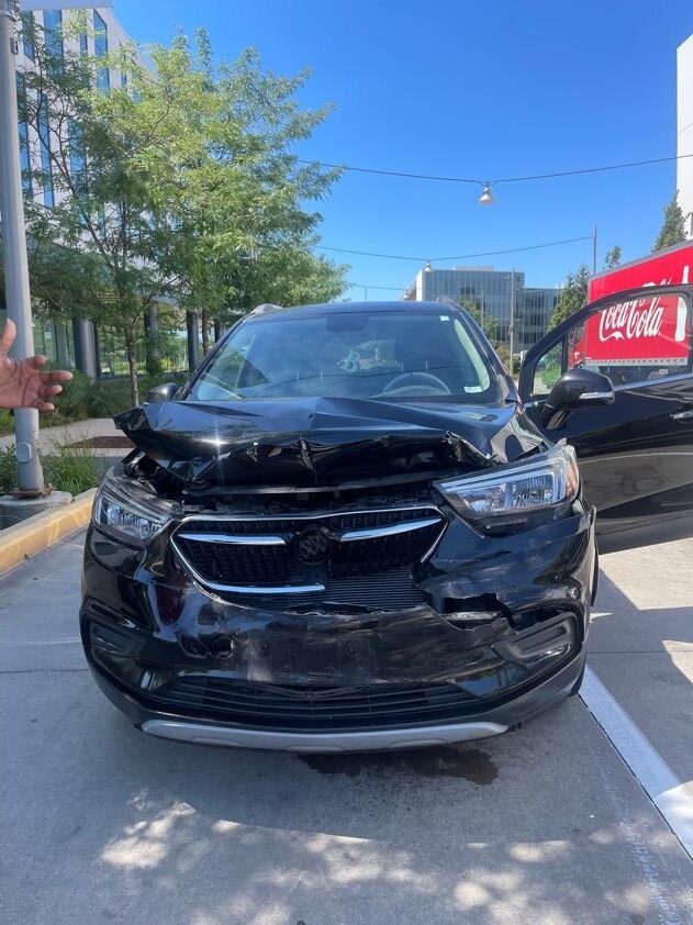 front end bumper of black car smashed in and damaged after accident