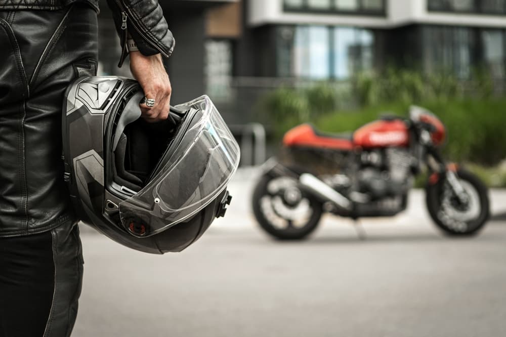 motorcyclist holding a helmet