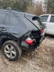 close up of rear end damage to black SUV after car crash