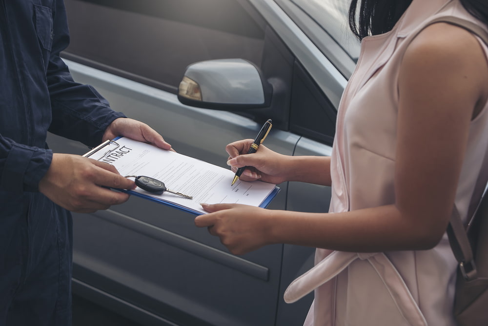 Woman and an agent signing a car rental agreement