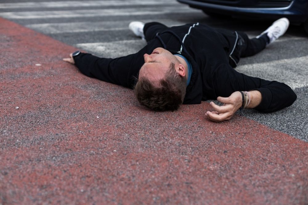 Pedestrian falls on the crosswalk after being hit by a vehicle