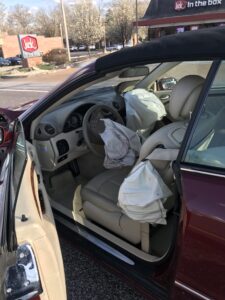 interior damage and airbag deployment in red sedan after car accident