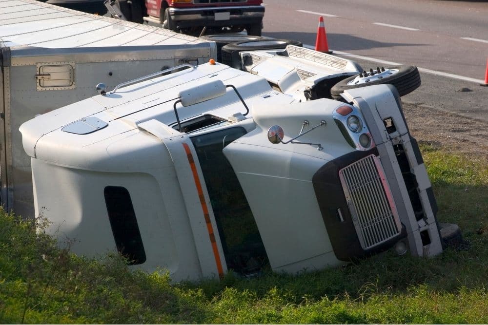 truck overturned on the side of the road after having been involved in an accident