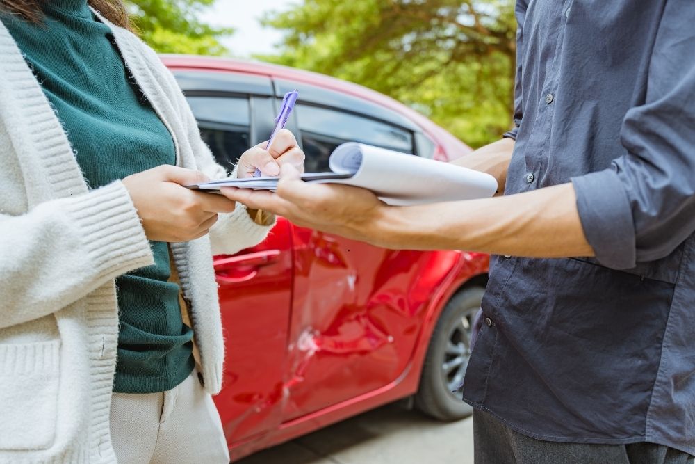Woman signing a document after a car crash