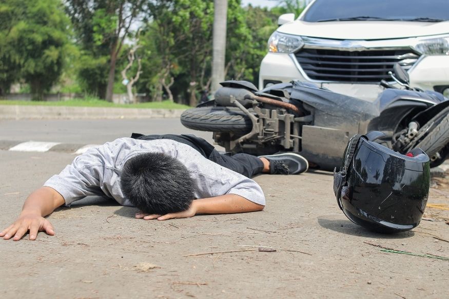 Man lying on the ground after suffering a car accident