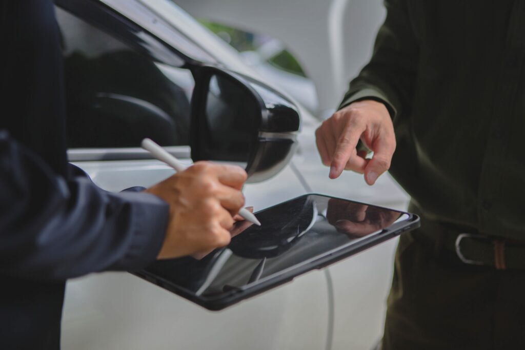 A technician documents vehicle assessment details on a digital tablet for St Louis uninsured motorist lawyers.